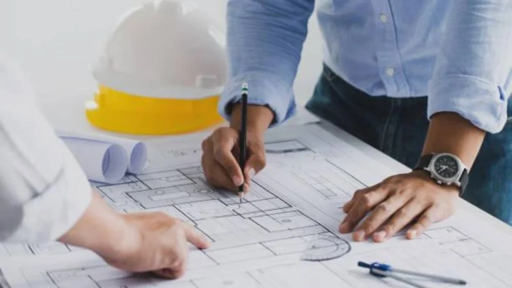 Building systems drawings with a hard hat on the plan table