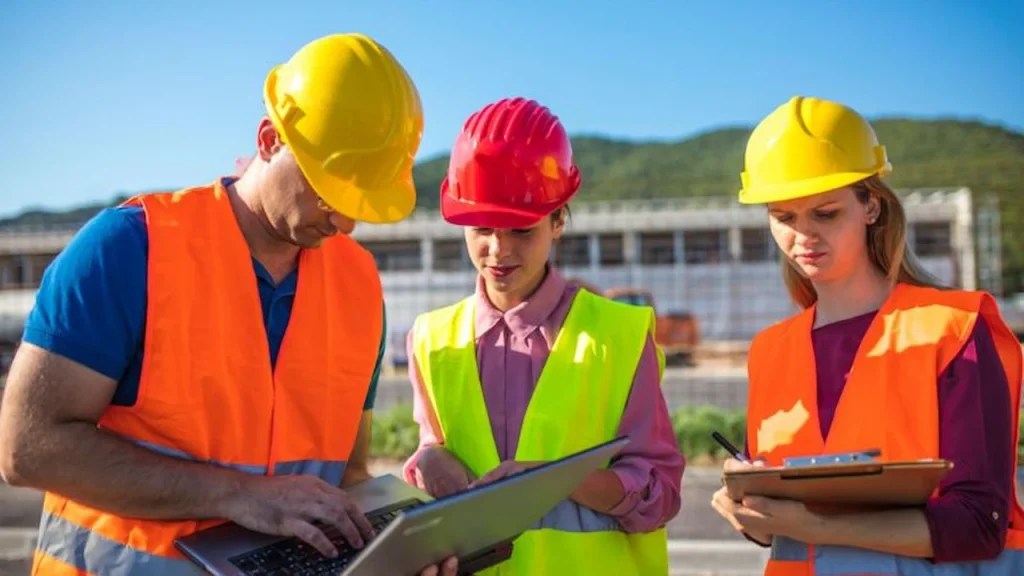 Construction team reviewing project drawings on a tablet at a job site
