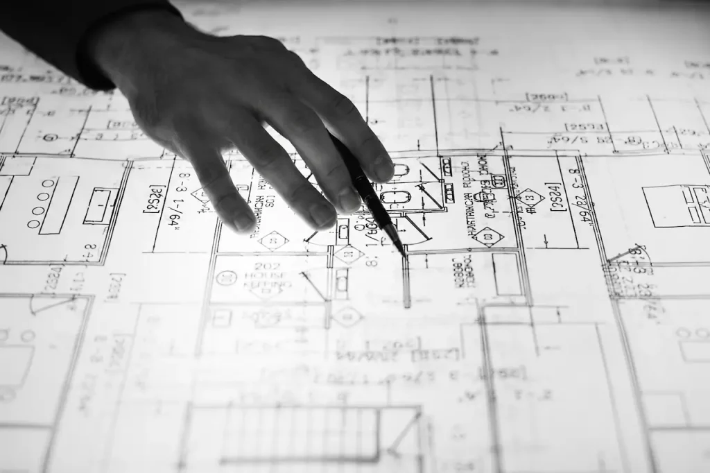 Reviewer pointing to notes on a permit drawing sheet