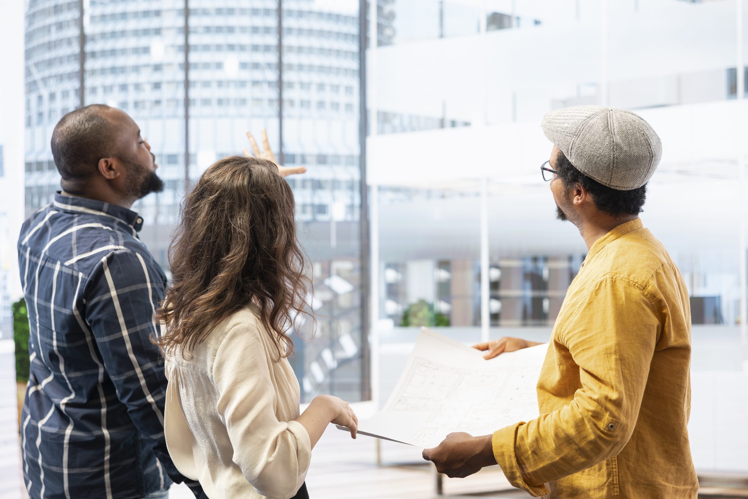 Property professionals discussing printed architectural plans at a table