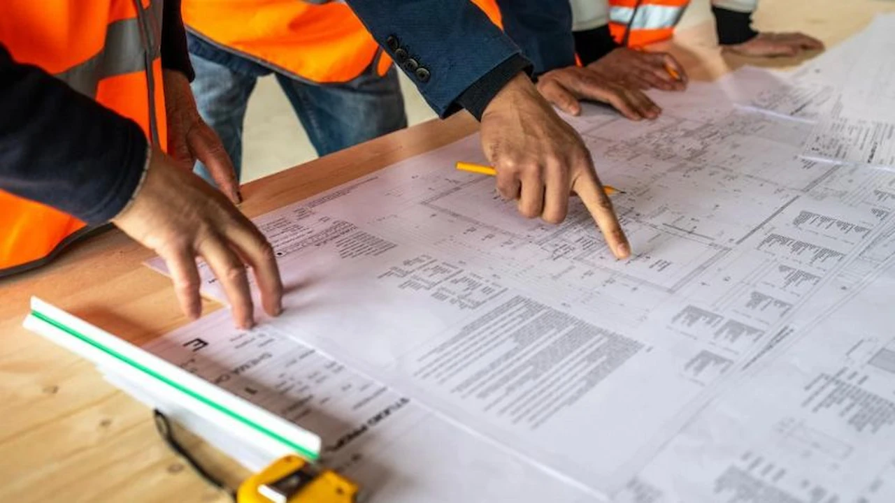 Professionals examining construction drawings for engineering coordination
